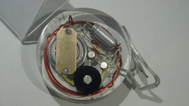 Chardack-Greatbatch-Pacemaker, der erste in Deutschland implantierte Herzschrittmacher aus dem Jahr 1961. Das Gerät besteht aus verschiedenen elektronischen Komponenten, darunter Spulen, Kondensatoren und Widerstände, die in einem runden Metallgehäuse untergebracht sind. 